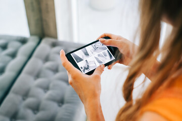 Caucasian woman monitoring security cameras on smartphone indoors, closeup.