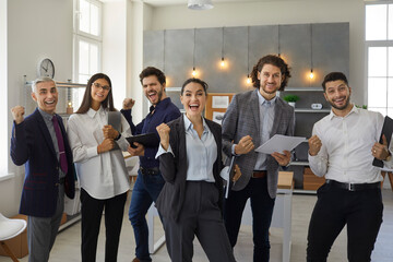 Yes we did it. Happy positive triumphant business team celebrating success. Group of euphoric office workers standing together, shouting Hooray, fist pumping after nailing presentation in work meeting