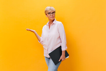 Wall Mural - Thoughtful woman in pink shirt and eyeglasses poses with documents