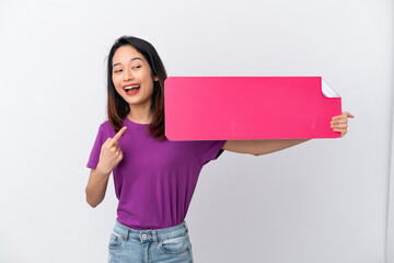 Young Vietnamese woman isolated on white background holding an empty placard and pointing it