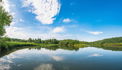 Wall Mural - panoramic landscape of a calm river. reflection of clouds on the lake.