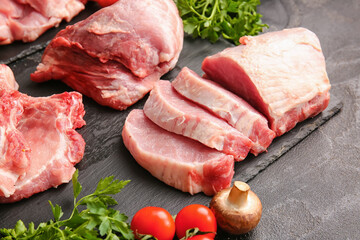 Slices of raw pork meat, parsley, mushroom and tomato on dark background, closeup