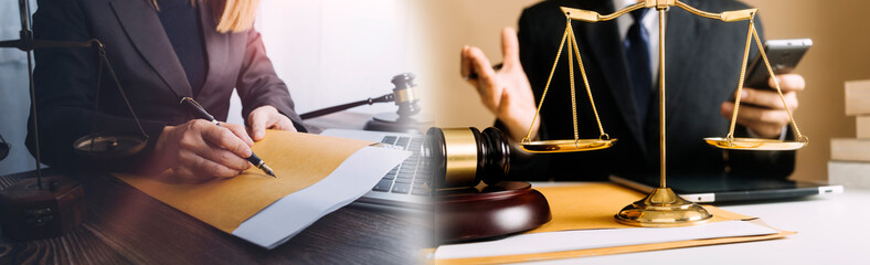 Justice and law concept.Male judge in a courtroom with the gavel, working with, computer and docking keyboard, eyeglasses, on table in morning light