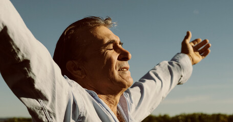 Brazilian farmer raising arms in coffee plantation praising god for the harvest. Brazilian man hands up at sky inside coffee plantation on sunny summer day. Concept of successful hard farm work.