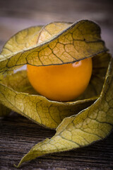 Wall Mural - Physalis or CapeGooseberry fruit over old wood background