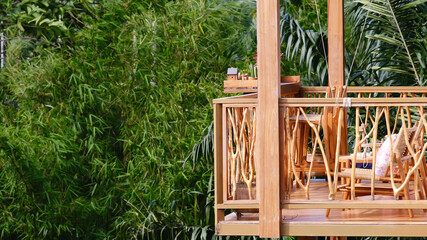 a balcony on the second floor of a wooden house in the forest.