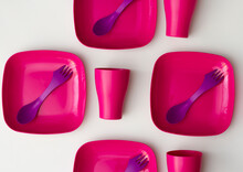 Purple Plastic Plates And Forks With A Spoon On A Bluish Background