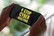 Text "STOP CYBERBULLYING" On Screen Of Mobile Phone. Concept :  Calling Everybody To Stop Bullying By Using Bad Word And Bad Texting  Social  Media Online Or Messaging Platforms.