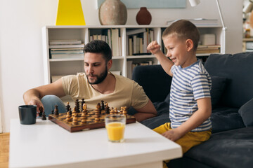 Wall Mural - father and son playing chess at home