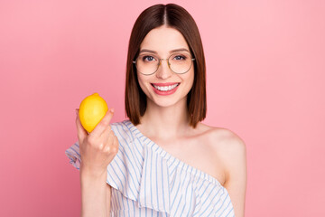 Wall Mural - Photo of young attractive woman happy positive smile hold lemon fresh food citrus eco isolated over pink color background