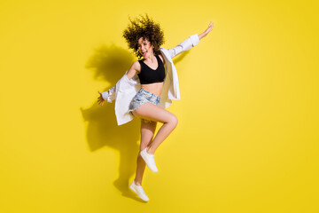 Wall Mural - Full size profile photo of optimistic pretty girl jump wear top shorts shirt sneakers isolated on yellow background