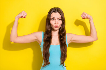 Sticker - Photo of active brunette hairdo millennial lady show muscle wear teal top isolated on vivid yellow color background