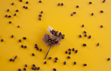 Poster - Top view of dry leaves and a heap of roasted coffee beans on a yellow surface