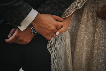 Poster - Groom and the bride holding each other's hands in the church during the wedding