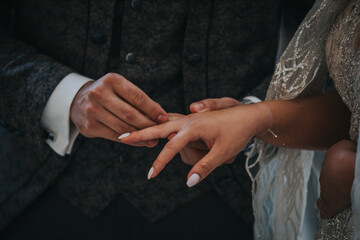 Poster - Groom putting the ring on the bride during the wedding ceremony at the church