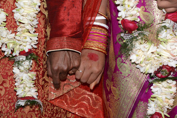 closeup shot of an indian couple holding hands during a traditional weddin