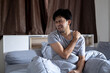 © anut21ng Stock - Young asian man with shoulder pain in bedroom, health problems