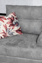 Canvas Print - Vertical shot of a grey, modern couch with a pillow in a room