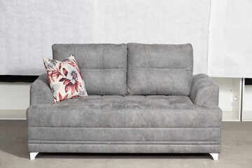 Wall Mural - Closeup shot of a grey, modern couch with a pillow in a room