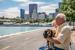 A cute dog, a Cavalier King Charles Spaniel, smiles and has a fun day out with its owners, a beautiful senior couple, visiting the lake.