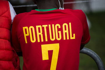 Closeup of african kid wearing a soccer shirt from portugal with the seven number in the street