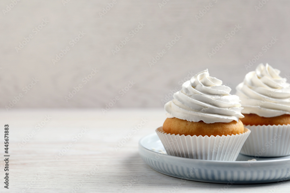 Delicious cupcakes with cream on white wooden table. Space for text - obrazy, fototapety, plakaty 