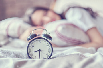 middle-aged woman sleeping and alarm clock in bedroom at home. sleep time concept