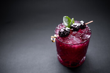 closeup of alcohol blueberry special cocktail with blackberry in wineglass