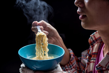 Close up of to man hand  pickup tasty noodles with steam and smoke in bowl