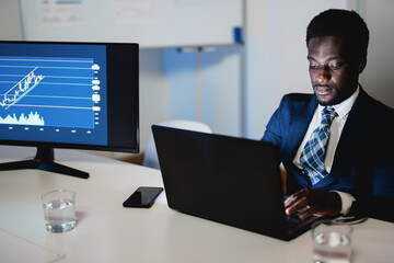 african man trader working inside hedge fund office - focus on face