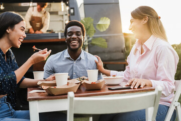 Multiracial people eating at food truck restaurant outdoor - Focus on african man face