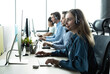 © opolja - How can I help you? Beautiful call center workers in headphones are working at modern office