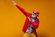© Look! - White bearded man in sunglasses and cap posing on orange background. Cool guy in red hoodie and leopard print t-shirt has fun..