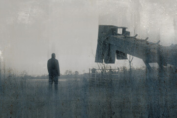 Wall Mural - A bleak, moody, winters day of a male figure standing next to quarry machinery in a field in the countryside. With a blurred, textured, weathered, abstract sepia edit.