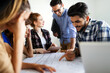 © NDABCREATIVITY - Happy multiethnic group of business people working together on meeting in office