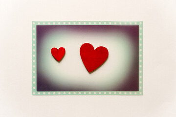 Sticker - themed photo overlay with two hand-painted wooden hearts on a light background with plenty of space for copy or text