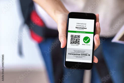 Disease immunity passport, Tourist uses of application on smartphone to show an international certification of vaccination at airport with Immunity passport and vaccination record card for covid-19