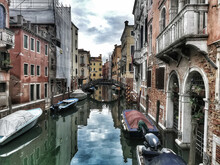 Canal With Boats On It Surrounded By Old Buildings In Venice, Ital