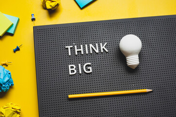 Wall Mural - Think big with text and lightbulb on desk worktable background.creativity and inspiration