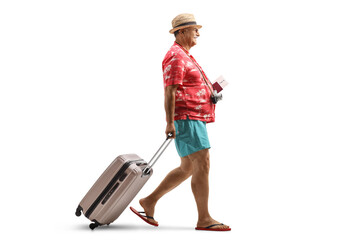 Poster - Full length profile shot of a mature male tourist holding a passport and pulling a suitcase