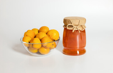 Wall Mural - Quince jam on a white background. Jar of jam and quince in a bowl.