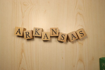 The word Arkansas was created from wooden letter cubes. Cities and words.