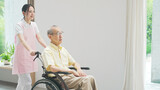 Fototapeta  - 車椅子を押す介護ヘルパー