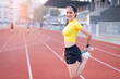 © EduLife Photos - A young beautiful Asian woman in sports outfits doing stretching before workout outdoor in the city stadium  in the morning to get a healthy lifestyle. Healthy young woman doing excercise