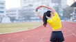 © EduLife Photos - A young beautiful Asian woman in sports outfits doing stretching before workout outdoor in the city stadium  in the morning to get a healthy lifestyle. Healthy young woman doing excercise