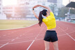 © EduLife Photos - A young beautiful Asian woman in sports outfits doing stretching before workout outdoor in the city stadium  in the morning to get a healthy lifestyle. Healthy young woman doing excercise
