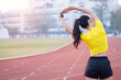 © EduLife Photos - A young beautiful Asian woman in sports outfits doing stretching before workout outdoor in the city stadium  in the morning to get a healthy lifestyle. Healthy young woman doing excercise