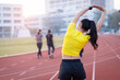 © EduLife Photos - A young beautiful Asian woman in sports outfits doing stretching before workout outdoor in the city stadium  in the morning to get a healthy lifestyle. Healthy young woman doing excercise