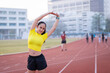 © EduLife Photos - A young beautiful Asian woman in sports outfits doing stretching before workout outdoor in the city stadium  in the morning to get a healthy lifestyle. Healthy young woman doing excercise