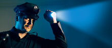 A Police Officer Cop Shines A Flashlight During An Investigation